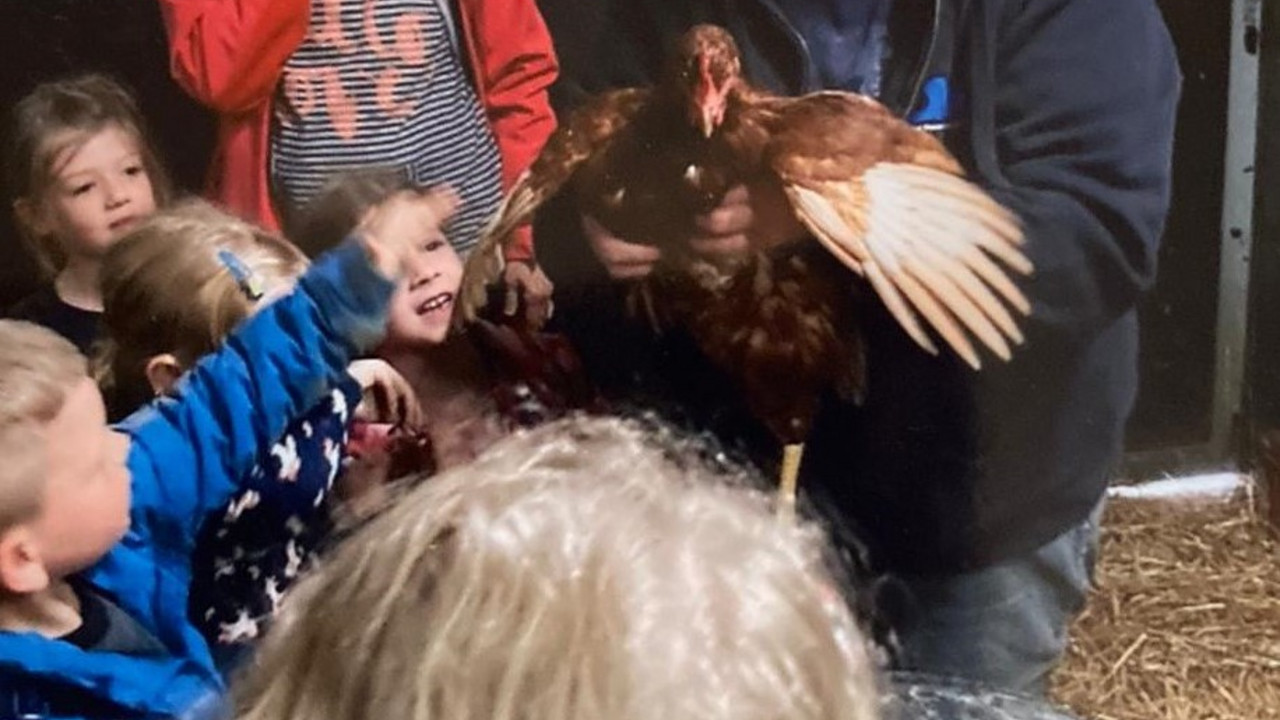 Sabine Nussbaum mit Huhn im Arm und Kindern.