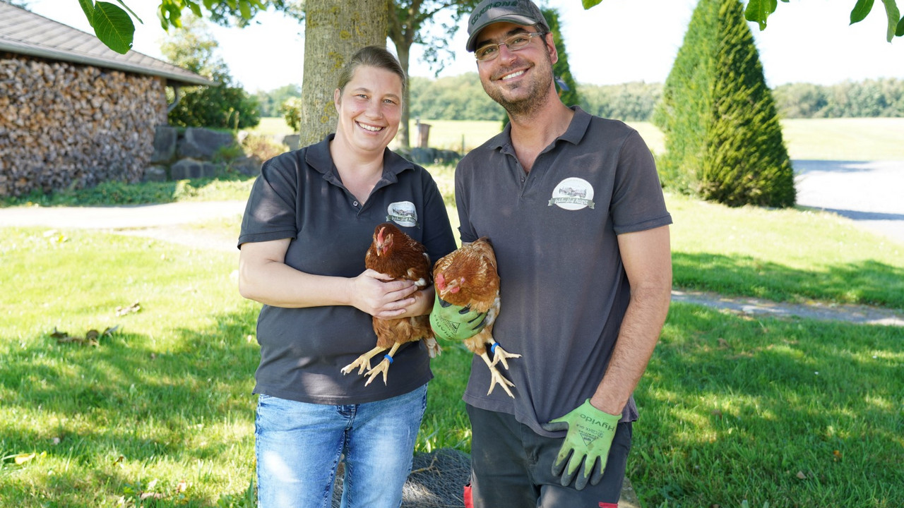 Silke Augst und Ehemann mit Hühnern im Arm.