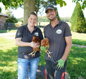 Silke Augst und Ehemann mit Hühnern im Arm.