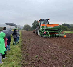 Kinder auf dem Feld mit Traktor.