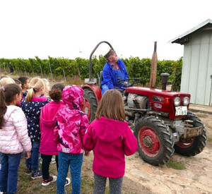 Senior Huxel erklärt Kindern die Winzerarbeit.